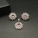 Jewelry set with pink gemstones and silver accents on a dark background
